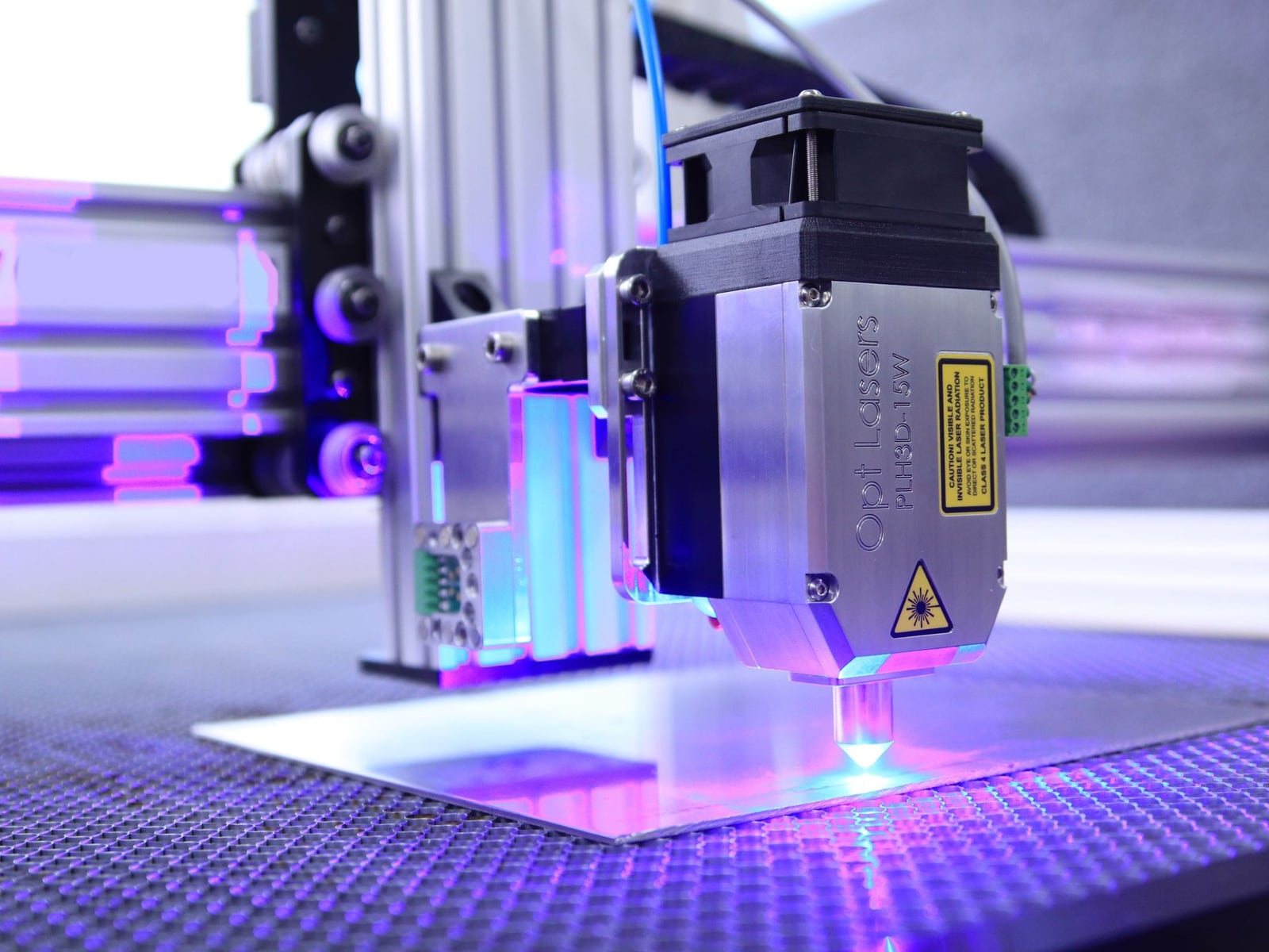 A CO2 laser machine cutting precise shapes from a clear acrylic sheet in a professional studio.